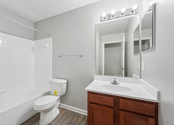 A white toilet sits next to a white sink in a small bathroom.